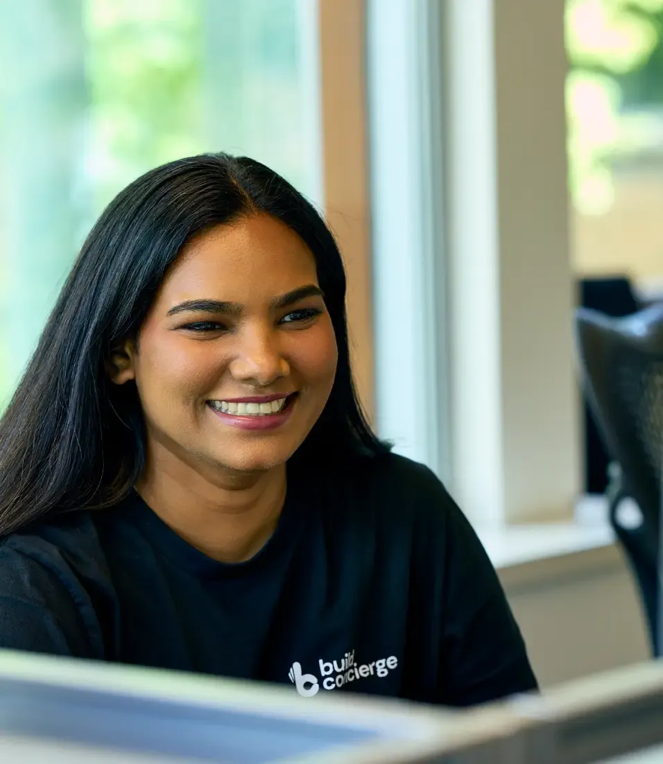 A developer at Build Concierge, smiling at a colleague. 